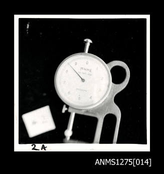 A Peacock Dial Swift Gauge, with a white rectangualr shaped object on the left hand side