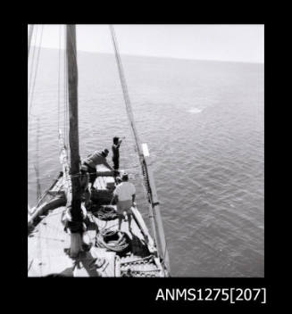 Two black-and-white negatives, joined together, of four men working on a pearl lugger