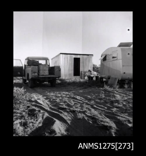 A caravan, shed and car on the sand