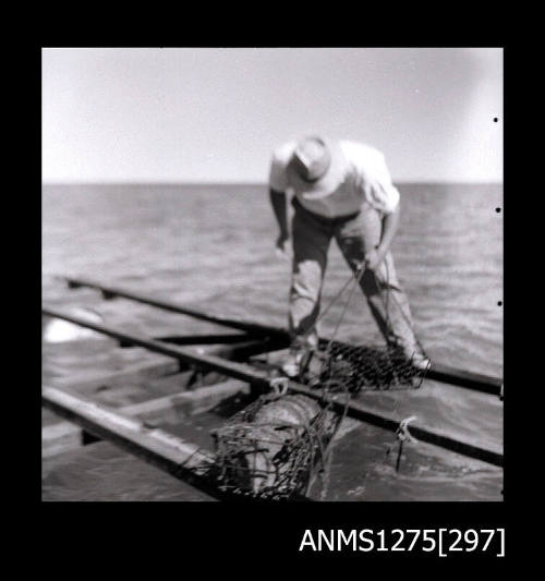 A man standing on a pearl raft, holding onto a pearl cage with rope