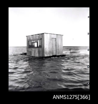 A pearl raft, largely consisting of a shed, with a small boat beside it