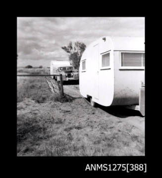 A caravan, being pulled by a car, with another caravan being pulled by a car in the background