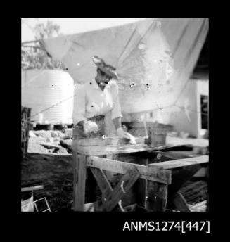 A person working at a bench under a shadecloth, on Packe Island