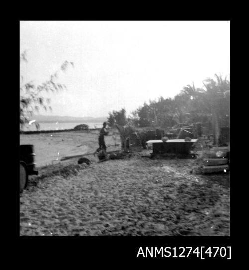 A man stading on a beach near equipment on Packe Island