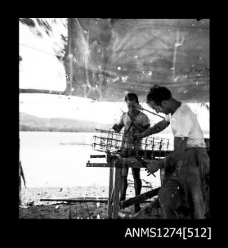 Two men constructing pearl cages on Packe Island