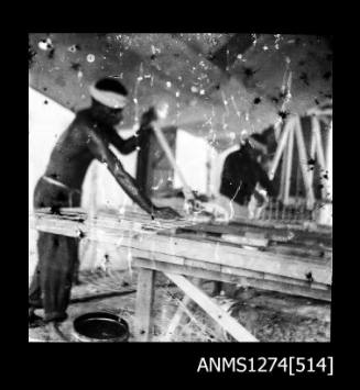 Two men constructing pearl cages on Packe Island