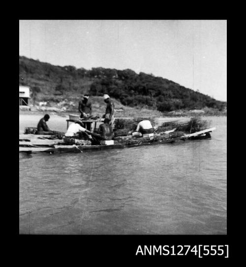 Several men working on a pearl raft on Packe Island