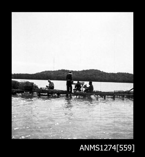 Several men working on a pearl raft on Packe Island