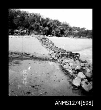 A rock wall on sand, on Packe Island