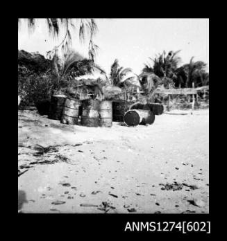 Metal cylinders and palm trees on a beach on Packe Island