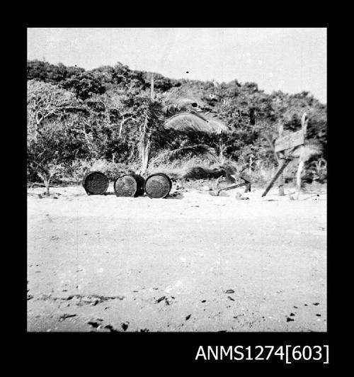 Metal cylinders and palm trees on a beach on Packe Island