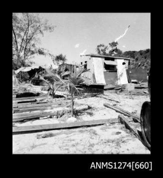 A shed, with piles of wood lying around it, on Packe Island