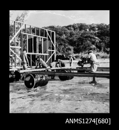 Several men constructing a lab, on the water, on Packe Island