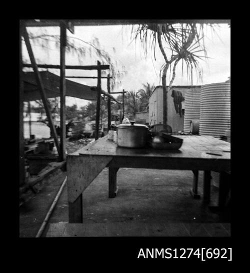 A table, next to wooden beams and a shed, on Packe Island