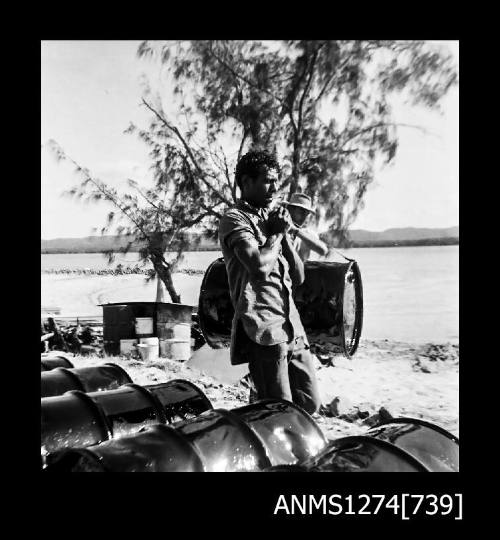 Man standing near metal drums on Packe Island