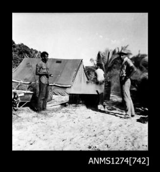 Three people standing near a tent on Packe Island