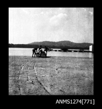 Four people on a beach in front of a pearl raft, on Packe Island