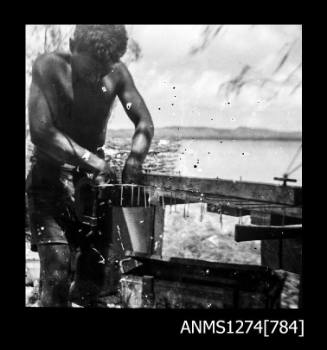 A man constructing a wire pearl cage on Packe Island