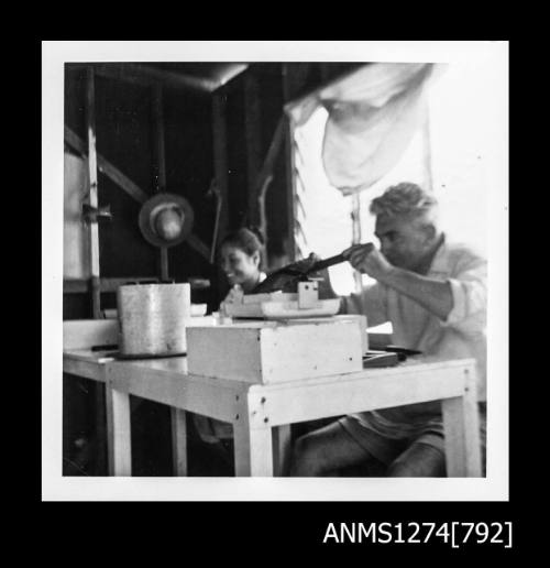 Yurie (or Yulie) George and a man seeding pearls in a shed on Packe Island