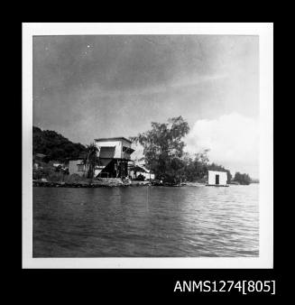 A two storey house on Packe Island, with a shed floating on a raft in the water