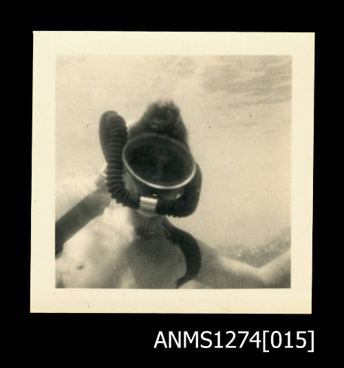 Photograph, of a man scuba diving underwater, in scuba diving gear, on Green Island