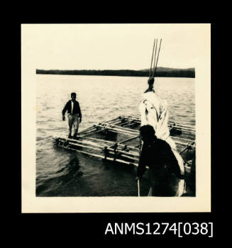 Two men on a metal pearl diving structure over the water, on Packe Island