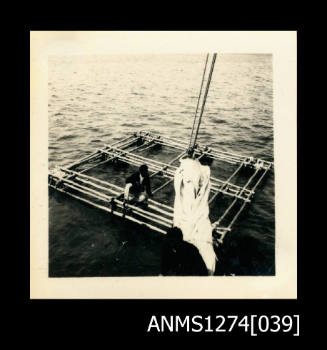 Two men on a metal pearl diving structure over the water, on Packe Island