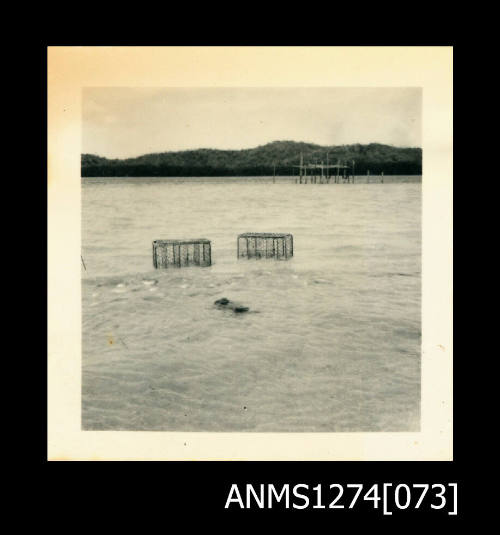 Two wire pearl cages in shallow water, on Packe Island