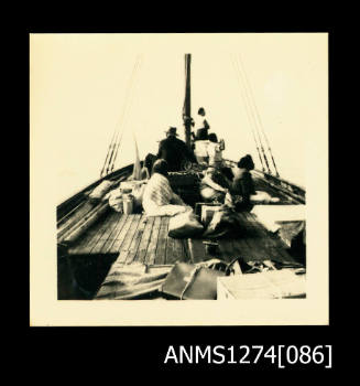 Photograph of several people sitting together in a boat, on Packe Island