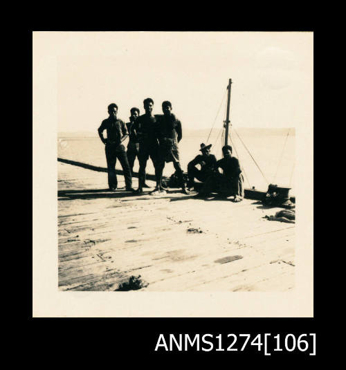 Photograph of six men, standing and sitting on a wooden wharf, on Packe Island