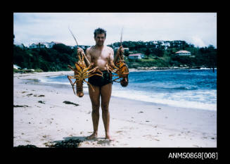 Wally Gibbons holding lobsters on a diving trip in New South Wales