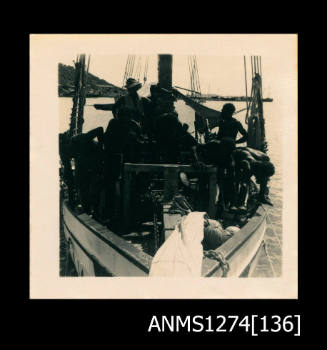 Photograph of several men in a boat, on Packe Island