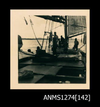 Photograph of several men standing on a boat, on Packe Island