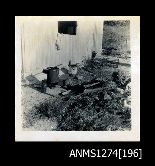 Pearling equipment, placed in front of a shed, including wire cages and metal buckets, on Packe Island