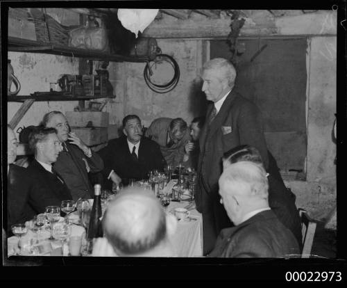 Count Felix Graf von Luckner smoking a pipe at a table with unidentified individuals