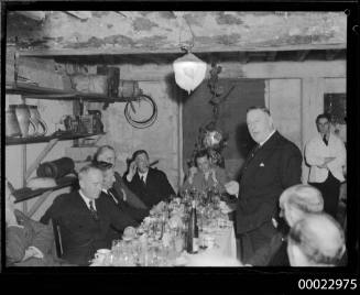 Count Felix Graf von Luckner smoking a pipe at a table with unidentified individuals