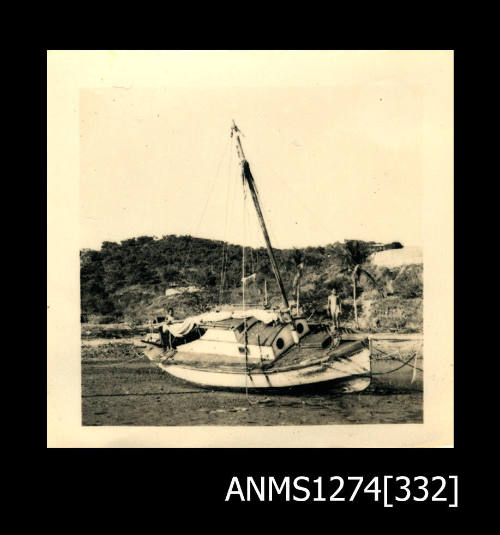 A boat, lying on its side on mud, on Thursday Island