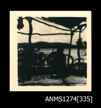 A shade cloth, with a man sitting underneath it, on Thursday Island