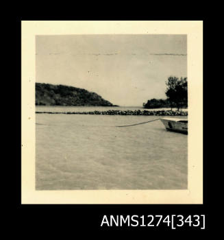 Photograph of land, beach, water and a boat on Packe Island