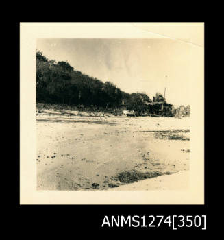 A beach, with a shade structure on the sand, on Packe Island