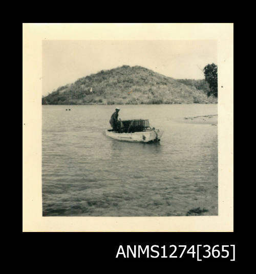 A man sitting in a boat with pearl cages, on Packe Island