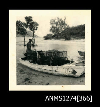 A man sitting in a boat with pearl cages, on Packe Island