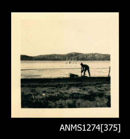 A man on a beach with a wooden box, on Packe Island