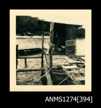 A wooden shed, sitting on a wooden structure over the water on Packe Island