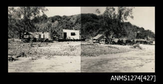 A beach with sheds and equipment, surrounded by trees on Packe Island