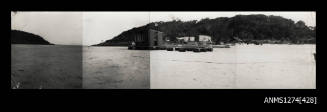 A beach, with a large shed sitting on containers, on Packe Island