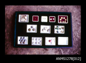 35mm colour transparency of a display box containing twelve small boxes with pearls, nuclei, etc