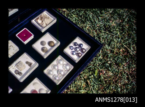 35mm colour transparency of a section of a display box, showing several small boxes containing pearls, nuclei, etc