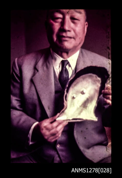 35mm colour transparency of a Japanese man holding a pearl shell with two blister pearls