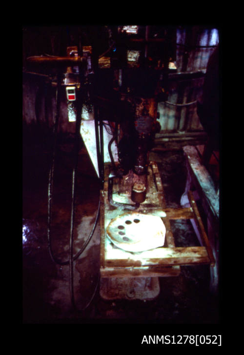 35mm colour transparency of a pearl cutting machine, with a pearl shell that has five holes cut out of it